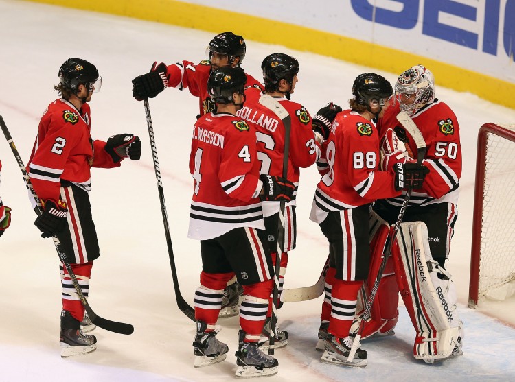 The Chicago Blackhawks congratulate goalie Corey Crawford after beating the Minnesota Wild Tuesday night. (Jonathan Daniel/Getty Images)