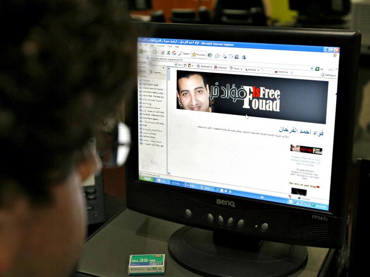 A journalist looks at the website of Saudi blogger and reform advocate Fouad al-Farhan flashing a banner that reads 'Fouad is Free.' (Marwan Naamani/AFP/Getty Images)