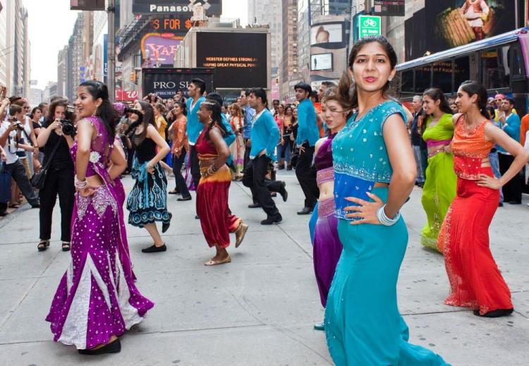 Dancers dressed in colorful Indian garb and disguised in everyday clothes perform a dance captures the attention of passer byers. (Cliff Jia/The Epoch Times)