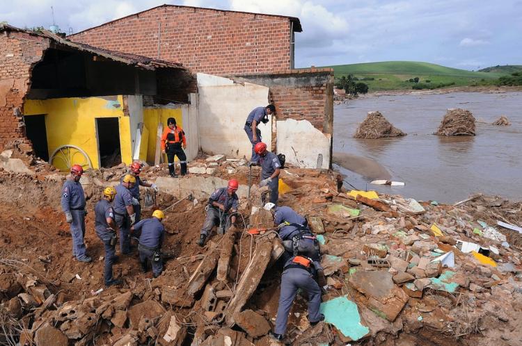 Rescuers search for victims from the damage caused by the flooding of the Mandau river, in Branquinha, Alagoas State, Brazil, on June 25. Additional rainfall over the weekend threatens more flooding to the already battered Brazil.  (Evaristo Sa/Getty Images)