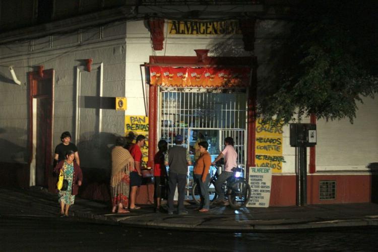 People gather outside a store after a power outage as they continue to deal with the aftermath of the Feb. 27th earthquake on March 14 in Santiago, Chile.  (Joe Raedle/Getty Images)