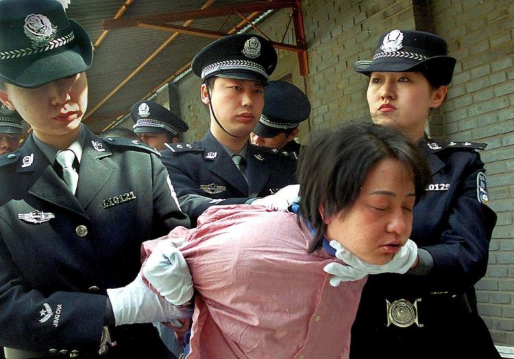 A woman prisoner is being taken away for her execution after she was sentenced to death at a sentencing rally in Beijing, China.  (AFP/Getty Images)