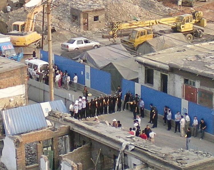 Demolition: In a typical scene in China, public security officials form a barrier to prevent residents entering an urban demolition and redevelopment site. (Blogger photo)