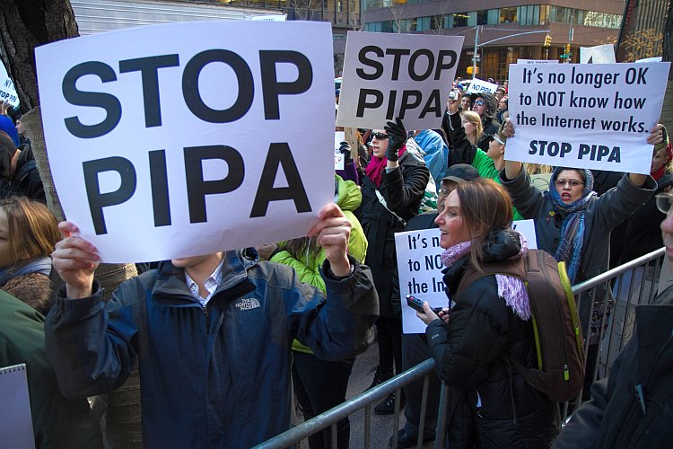 Demonstrators hold signs against proposed laws SOPA and PIPA