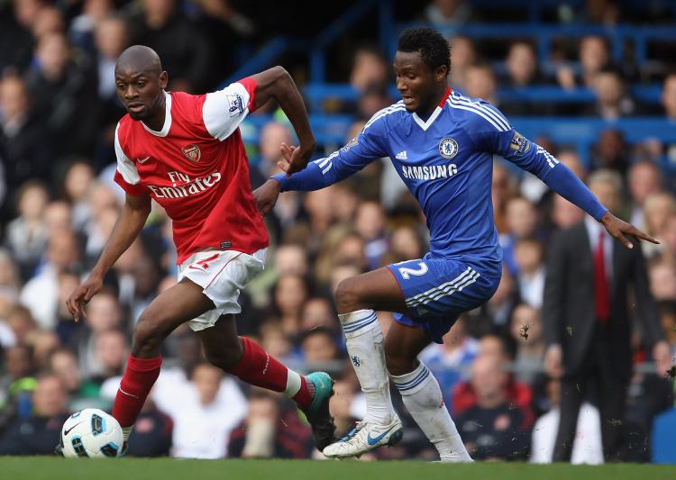 Arsenal's Abou Diaby tries to evade Chelsea's Michael Essien in Sunday's English Premier League clash. (Bryn Lennon/Getty Images)
