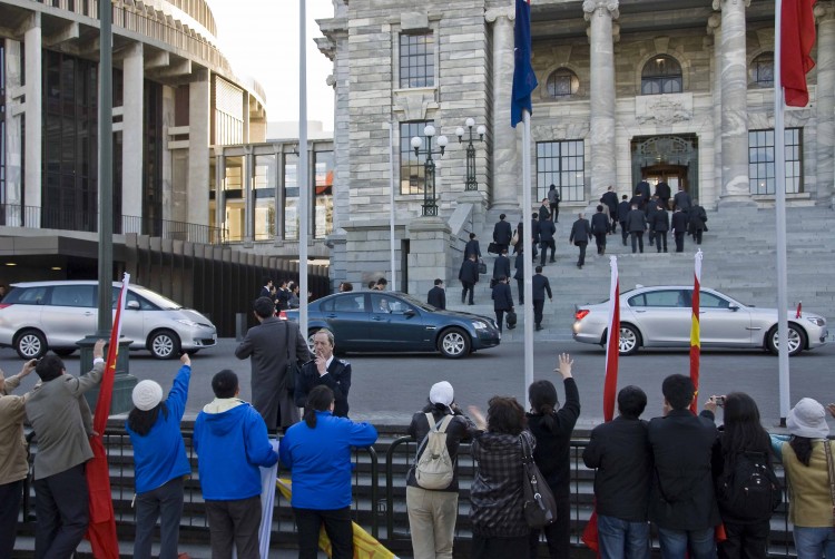 Falun Gong protesters asked to take banners down. The official Chinese delegation mounts the steps of Parliament, Wellington. (Epoch Times)