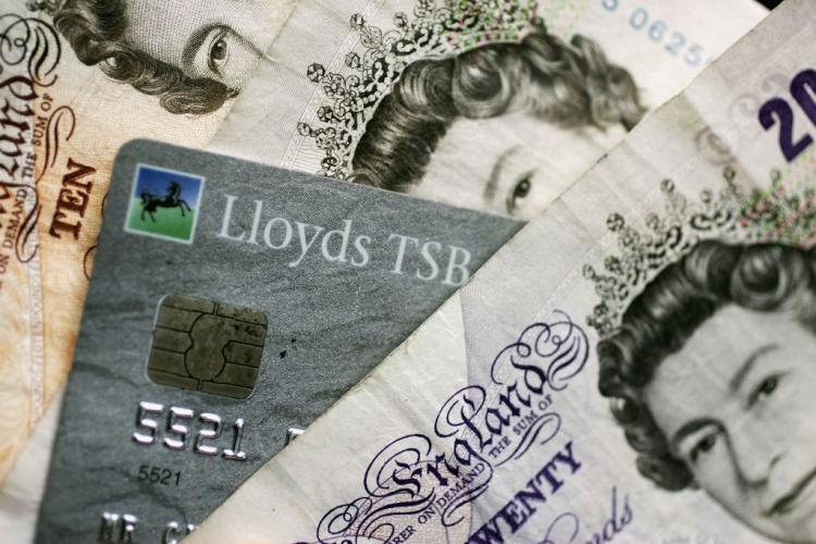 CASH OR CREDIT? A chip-and-PIN card is mixed in with Bank of England notes. (Christopher Furlong/Getty Images)