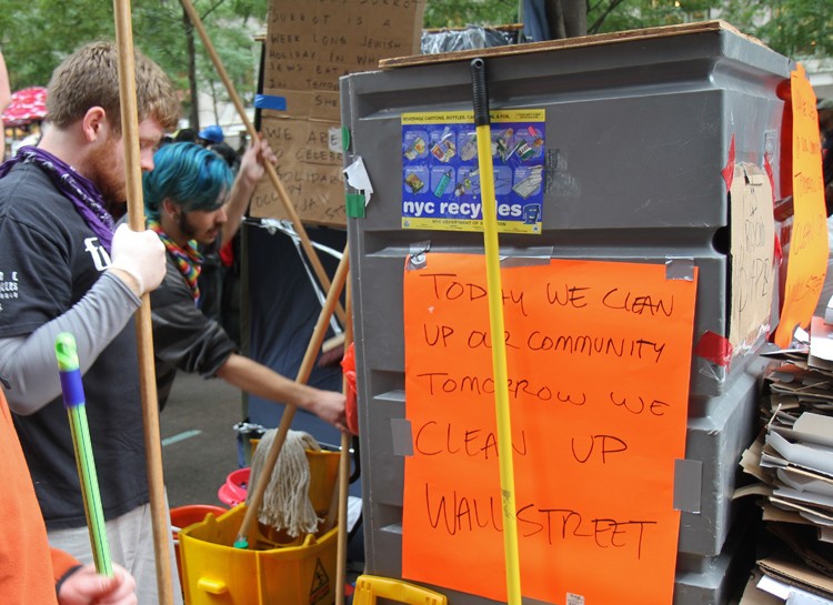Occupy Wall Street protesters grab mops and brooms to clean Zucotti Park, where they've been camping for almost two weeks, in Lower Manhattan on Thursday.(Zack Stieber/The Epoch Times)