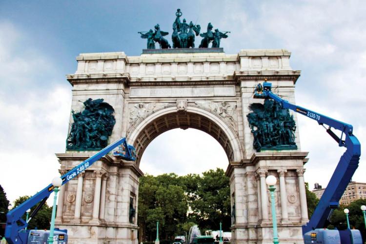 Reaching heights of up to 135 feet, city employees work on tall lifts to clean and preserve Soldiers and Sailors Memorial Arch. (Cliff Jia/The Epoch Times)