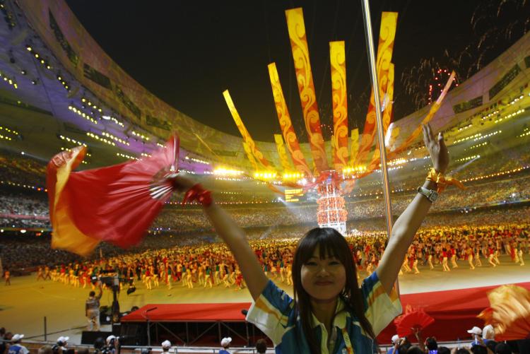 An audience member cheers during the closing ceremony of the Beijing Olympics. (Adrian Dennis/AFP/Getty Images)