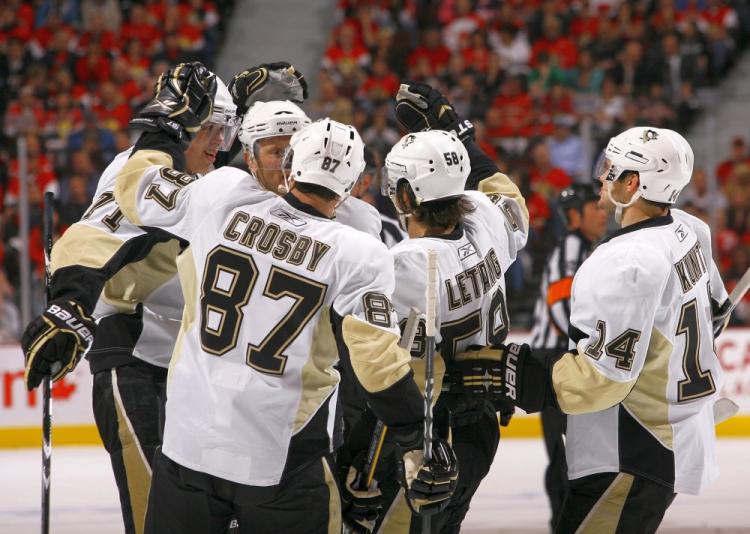 Sidney Crosby, who had a four-point night against the Senators on Tuesday, congratulates Evgeni Malkin for his opening goal. (Phillip MacCallum/Getty Images)