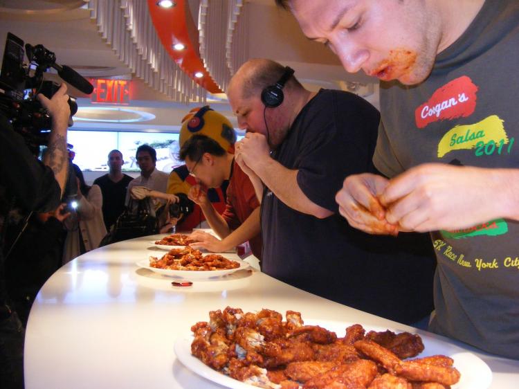 WING EATERS: First-place winner Will Millender (C), second-place winner Derek O'Gall, and third-place winner Andrew Tsang (L) in the final round of the Kyochon hot wings eating contest held on Sunday at the chainâ��s Manhattan store on 32nd Street at Fifth Avenue. (Gidon Belmaker/The Epoch Times)