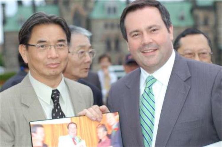 Citizenship and Immigration Minister Jason Kenney poses with Joseph Iam, one of several Chinese Canadians who came to Parliament Hill Wednesday afternoon to thank Kenney for the work he did on the issue of the Chinese head tax. (Matthew Little/The Epoch Times)
