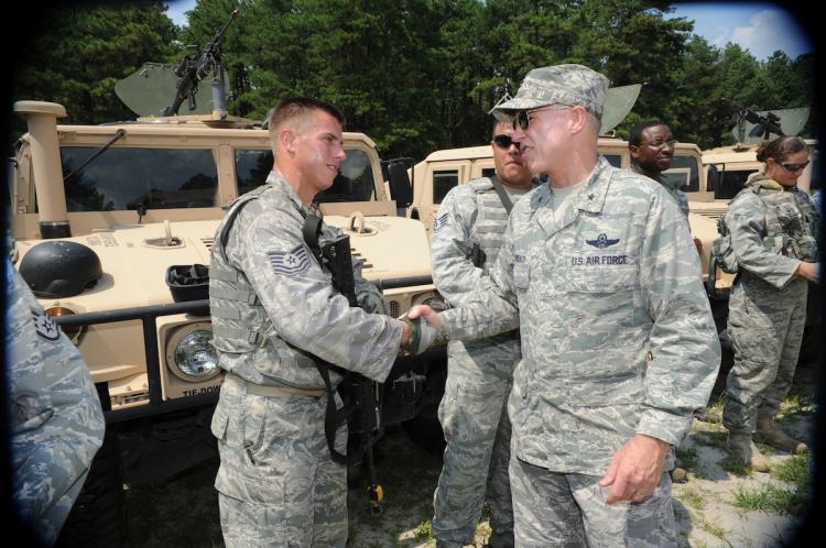 EXPERT PREPARATION: Brig. Gen. Richard Devereaux, U.S. Air Force Expeditionary Center commander, greets Tech. Sgt. James Chubb, 421st Combat Training Squadron, after a convoy demonstration for civic leaders during the Center's Outreach Day, July 21 at Joint Base McGuire-Dix-Lakehurst, N.J. (U.S. Air Force photo by Carlos Cintron)