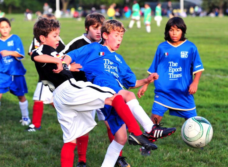 Epoch Times-Team Italy's and Davenport Kitchens-Team Germany's 11-year-old teammates work hard for the ball. (Gordon Yu/The Epoch Times)