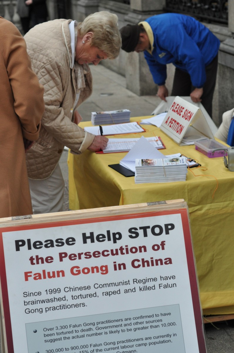 Woman signing a petition to call on Taoiseach (Prime Minister) Enda Kenny to urge China to end the persecution of Falun Gong (Martin Murphy/The Epoch Times)