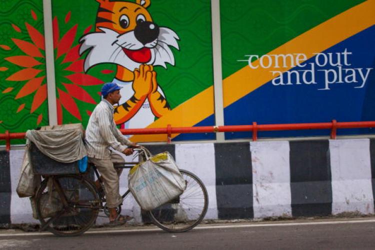 An Indian commuter cycles past a banner for the Commonwealth Games on September 23, 2010, in New Delhi, India. Delhi is scrambling to clean up the athletes' village following numerous complaints from officials.  (Daniel Berehulak/Getty Images)