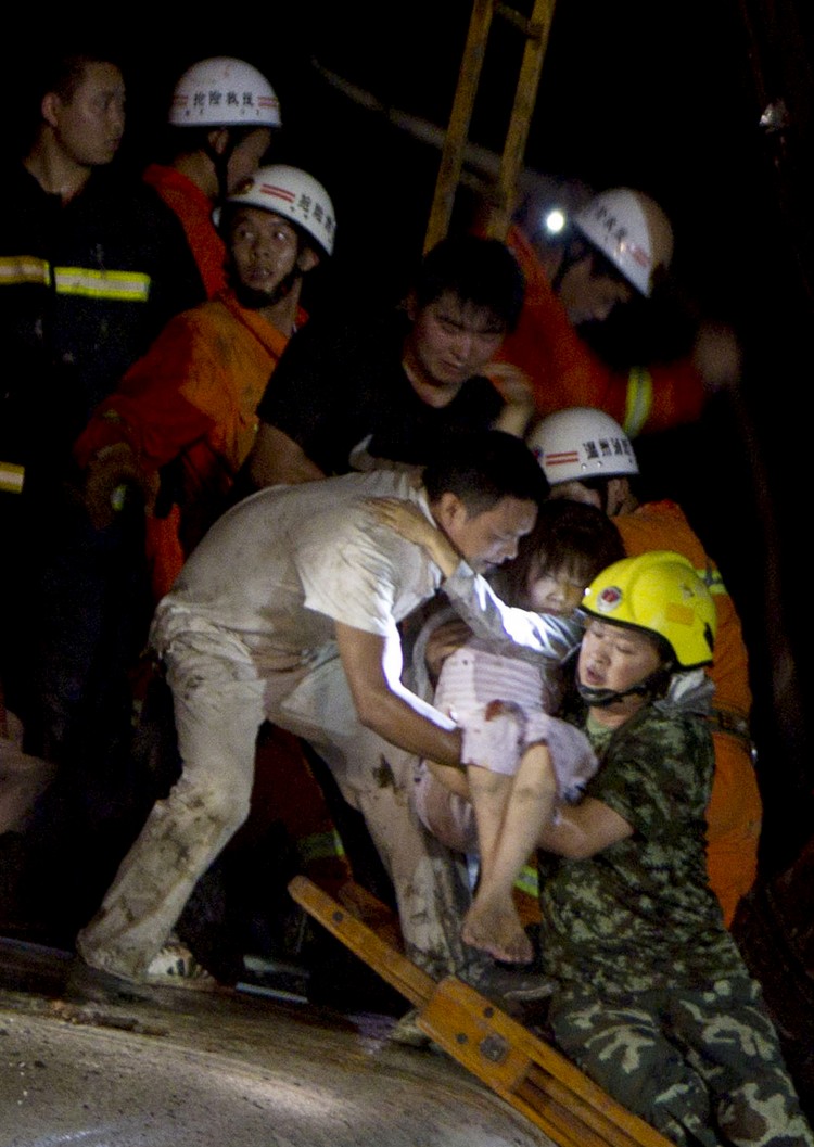 Rescue workers carry an injured girl as they tend to the victims of a high-speed train accident on July 23, 2011, near Wenzhou City, China. (STR/AFP/Getty Images)