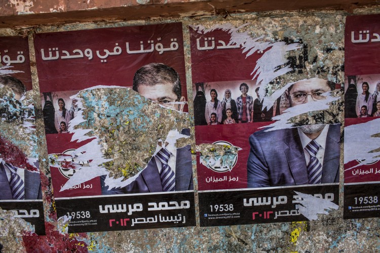 Torn campaign posters of presidential election candidate Mohhamed Morsi