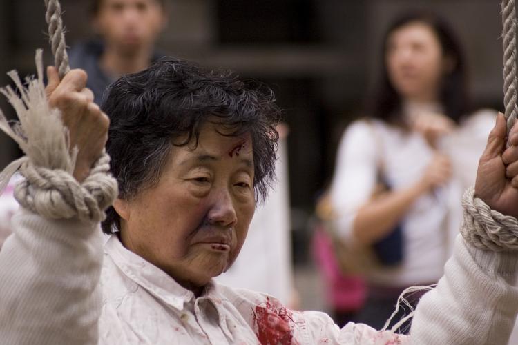 ESCALATED PERSECUTION: A Falun Gong practitioner participates with others in a torture reenactment during a 2008 protest of China's human rights abuses, Melbourne, Australia. (Jarrod Hall/The Epoch Times)