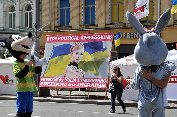 Football fans pose next to a banner calling for the release of Ukraine's jailed ex-premier Yulia Tymoshenko