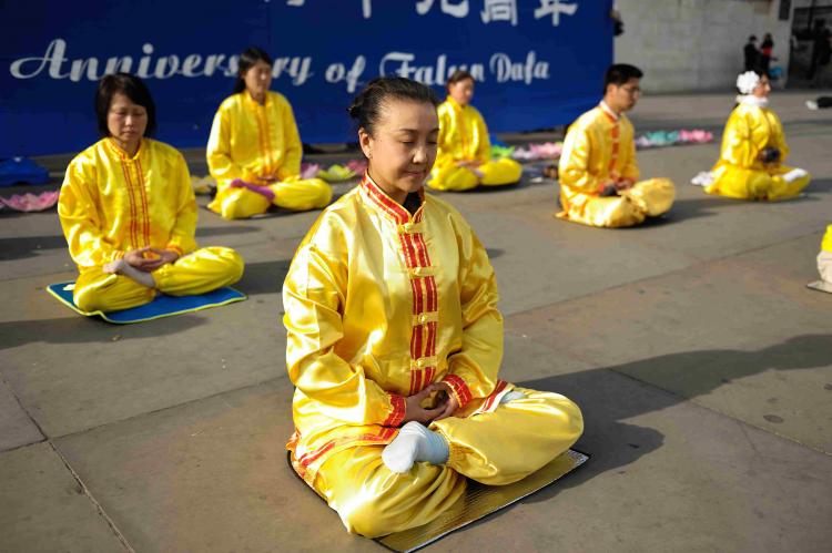 Falun Gong practitioners demonstrate the sitting meditation during World Falun Dafa Day celebrations in Trafalgar Square. (Edward Stephen/Epoch Times)
