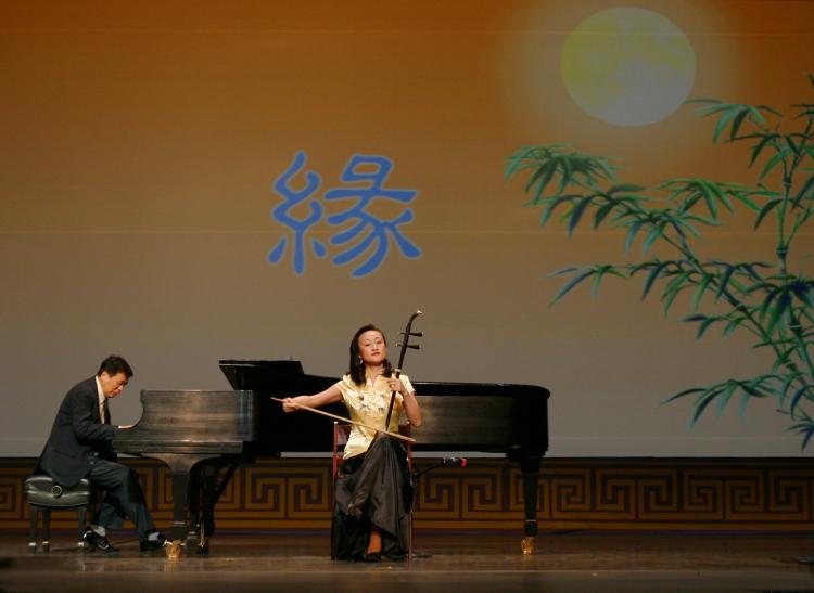 The unique melancholic sound of Ms. Qi Xiaochun's Erhu, a tiny bowed instrument, enthralls an entire audience. (Courtesy of Divine Performing Arts)