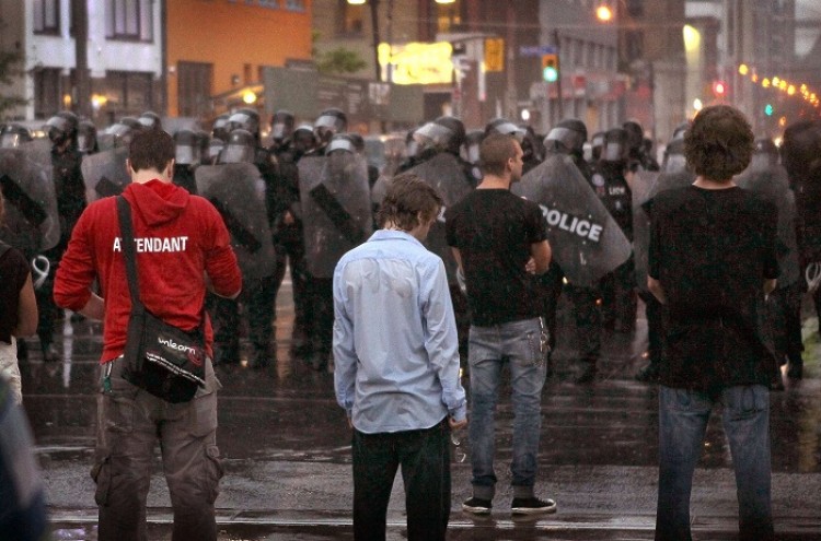 Police officers hold back demonstrators at the G20 summit in Toronto. Critics say that many questions still remain unanswered after the Toronto Police Service released the G20 After Action Review last week. (Scott Olson/Getty Images)