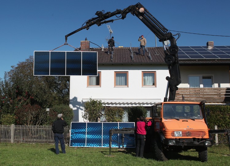 THE GERMANS ARE VERY EFFICIENT: Workers fit solar power modules to the roof of a house on October 15th, 2011 in Wessling, Germany