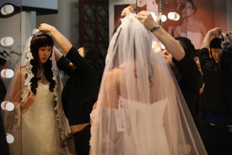 A Chinese woman tries on a wedding dress at the 2012 China Spring Wedding Expo at Beijing Exhibition Center on February 17, 2012 in Beijing (Feng Li/Getty Images)