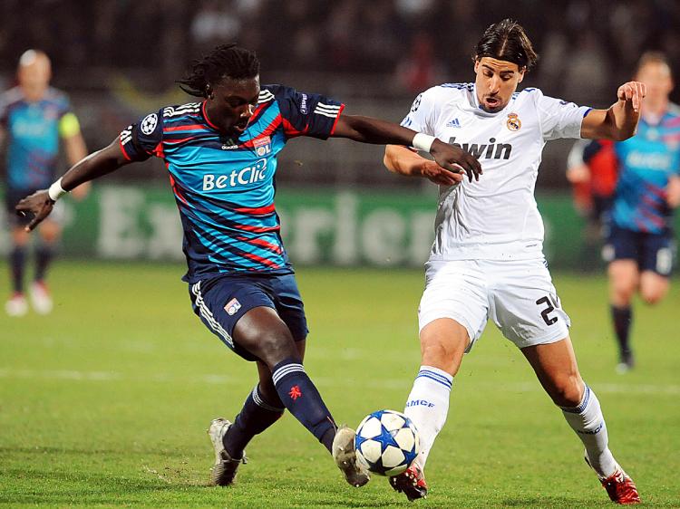 CHAMPIONS LEAGUE: Lyon's Bafetimbi Gomis and Real Madrid's Sami Khedira challenge for the ball in Tuesday's action. (Philippe Merle/AFP/Getty Images)