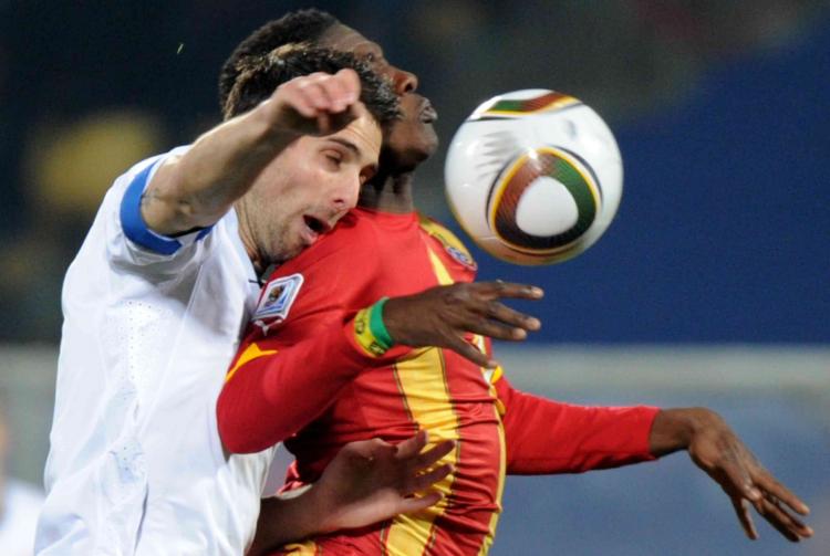 Asamoah Gyan (R) controls a high ball on his way to the winning goal as Carlos Bocanegra defends.
