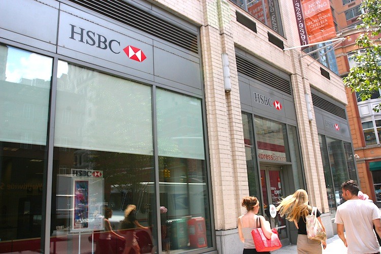 SHEDDING BRANCHES: Young people walk past an HSBC bank in midtown Manhattan, August 1. The banking giant is looking to shed retail bank branches in New York to focus more on investment and corporate banking. (Jaya Gibson/The Epoch Times)