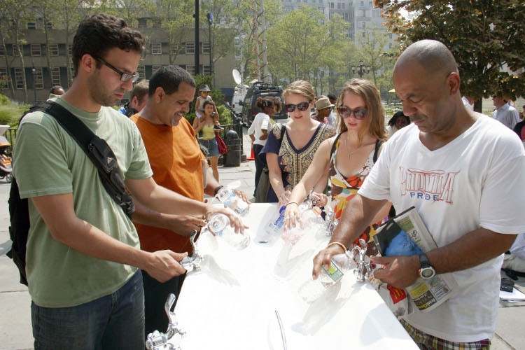 COOLING OFF: With temperatures in the mid-90s on Thursday, passersby fill water bottles and get some much needed refreshment from a portable water fountain, part of the city's Water-On-The-Go program, outside Brooklyn Borough Hall on Thursday. (Ivan Penchoukov/The Epoch Times)