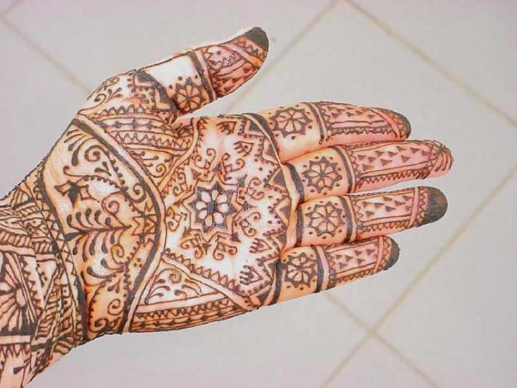 Paste ground from the dried leaves of the henna plant is being applied to the skin using a tube. (Photo courtesy of Kree Arvanitas )