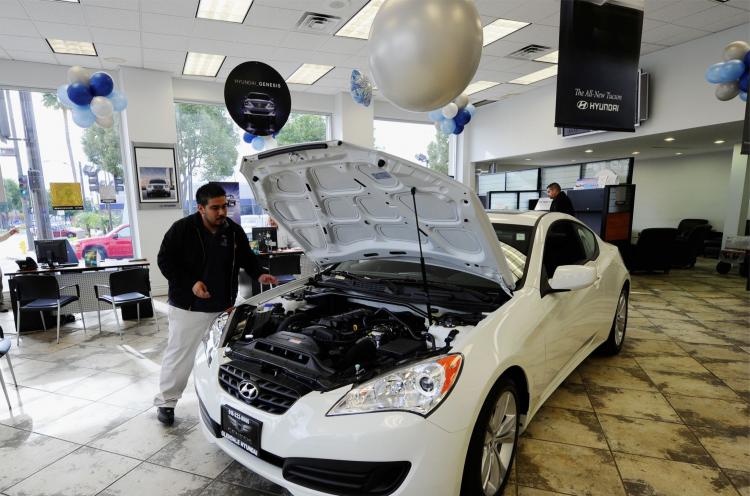 SELLING FAST: Workers move a 2011 Hyundai Genesis Coupe for display in the showroom at a Hyundai dealership in Glendale, Calif. (Kevork Djansezian/Getty Images)