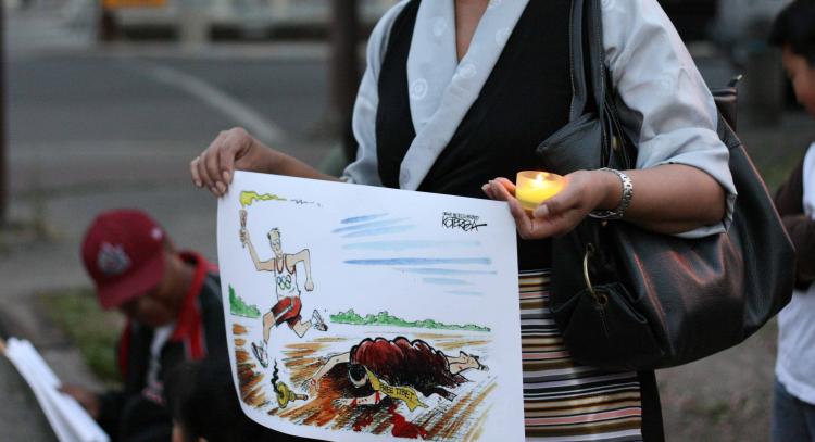 RIGHTS TRAMPLED: Tibet supporter holds a commentary cartoon on the Beijing Olympics during a candlelight vigil at the Chinese Consulate in Calgary on August 7.  (Neil Campbell/The Epoch Times)
