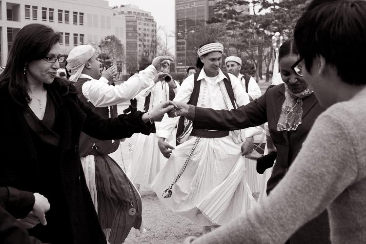 Tunisian citizen Soad Ayadi (left) dances with other Tunisian expatriates to celebrate their country's independence and freedom from dictatorship in Daejeon, South Korea. ( Jarrod Hall/The Epoch Times )