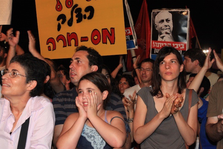 SENDING A MESSAGE: Israelis join a mass rally of tens of thousands in Tel Aviv on Saturday near the Tel Aviv Museum, carrying signs such as, 'Bibi Go Home,' referring Prime Minister Netanyahu. They are demonstrating against the housing crisis and other economic woes. (Yaira Yasmin/The Epoch Times)