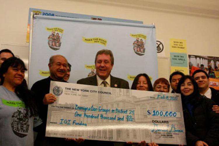 BIG MONEY: City Councilman Daniel Dromm, also chairman of the Immigration Committee, hands over a check to immigration groups in Jackson Heights.  (Tara MacIsaac/The Epoch Times)