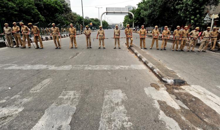 Delhi Police officials stand guard during a nationwide strike in protest of fuel price hikes in New Delhi, July 5.  (Manan Vatsyayana/Getty Images )