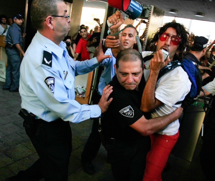 CONFRONTATION: Tel Aviv police and demonstrators clash outside City Hall on Wednesday after municipal authorities moved in to dismantle the tent town erected in July to protest against the high cost of living in Israel. (Yaira Yasmin/The Epoch Times )