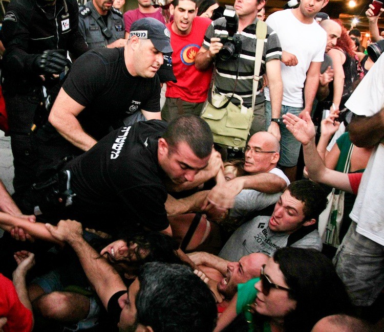 Tel Aviv police try to move demonstrators who had been sitting on the street. (Yaira Yasmin/The Epoch Times)