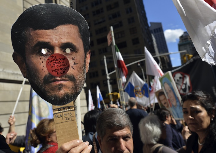 Demonstrators hold a sign in protest against Iranian President Mahmoud Ahmadinejad's visit outside of the Warwick Hotel in New York City on Sept. 24, 2012. (Timothy A. Clary/AFP/Getty Images)