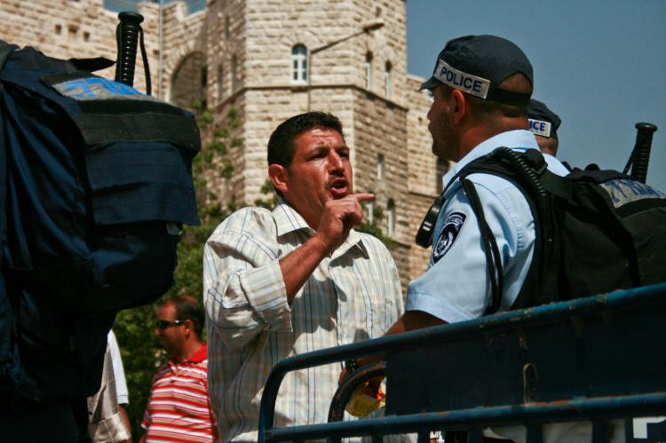 MIDDLE EAST DISCUSSIONS: An Arab man argues with an Israeli police officer near Al Aqsa Mosque in Jerusalem.  (Genevieve Long/The Epoch Times)