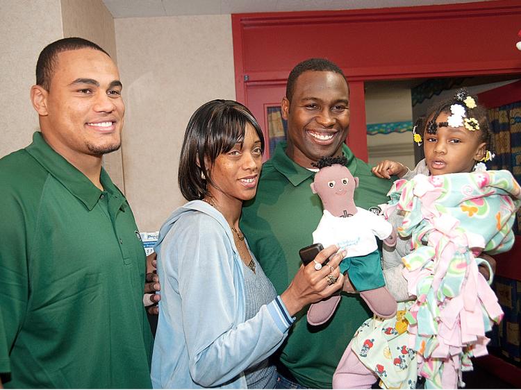 KINDNESS: Dustin Keller (L) and Tony Richardson (R) of the New York Jets give out Shadow Buddies to children at Woodhull Medical Center in Brooklyn on Tuesday. (Ray Gibson)
