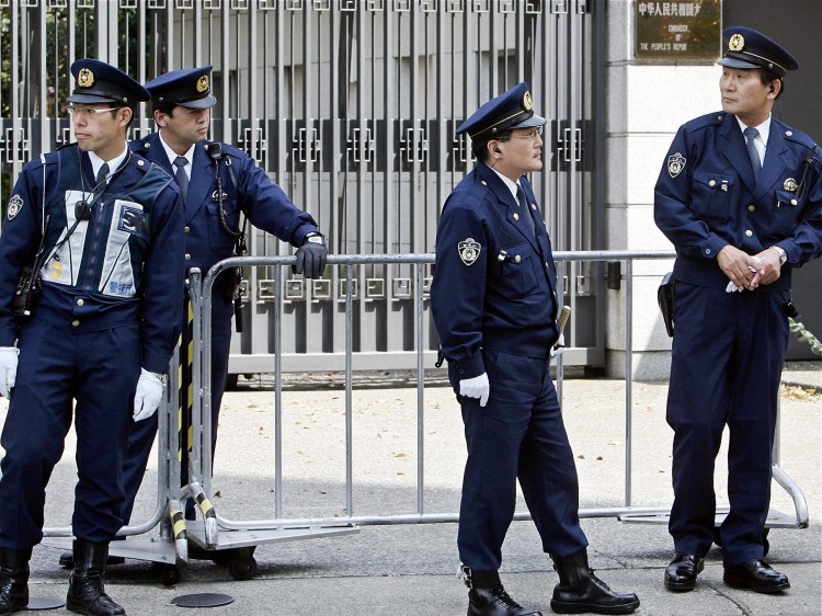 Policemen stand guard in front of the Chinese Embassy in Tokyo