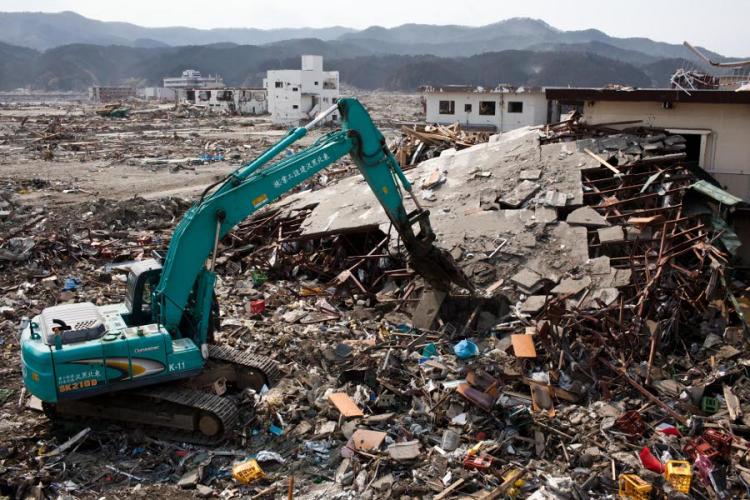 Japanese workers use a hydraulic machine to demolish a wrecked building in the tsunami-devastated town of Rikuzentakata, Iwate prefecture, on April 2, 2011. (Yasuyoshi Chiba/AFP/Getty Images)