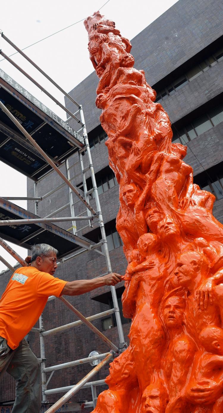 Danish artist Jens Galschiot painted his artwork Pillar of Shame orange, a color symbolizing discontent with the Chinese regime.  (Ted Aljibe/Getty Images)