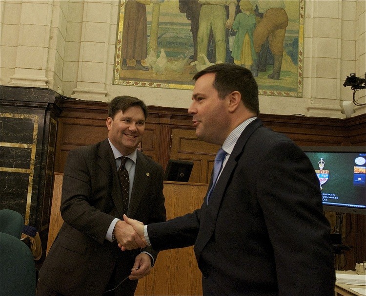 Immigration Minister Jason Kenney shakes hands with his NDP critic Don Davies at the Standing Committee on Immigration and Citizenship on Oct. 20. (Matthew Little/The Epoch Times)
